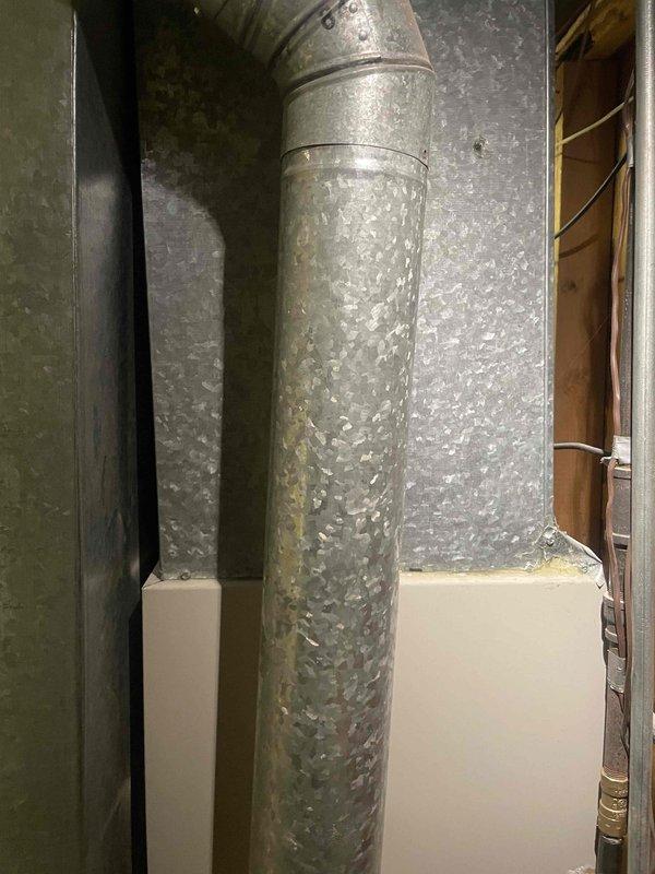Conducted comprehensive evaluation of existing HVAC system for full replacement estimate. Inspected 15-year-old Kelvinator 2 furnace with 80.0 AFUE rating and 10-year-old air conditioning system located in basement utility area. Assessed condition of gas supply line, ductwork connections, and ventilation system. Documented crystalline mineral buildup on vertical supply duct indicating potential condensation or humidity issues. Evaluated installation space, existing infrastructure including concrete floor placement, and accessibility for equipment replacement. Provided estimates for replacement furnace, air conditioning unit, and optional water heater replacement to meet customer's timeline of replacement within one month.