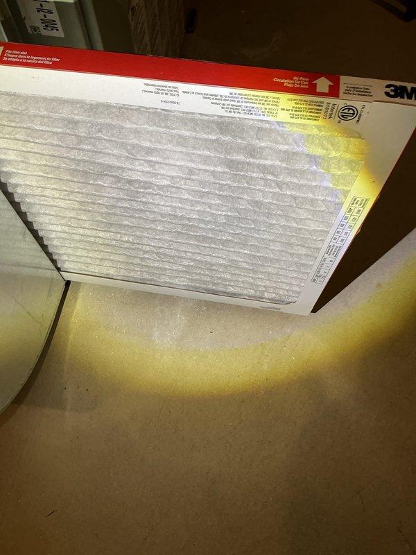 Performed routine air conditioning maintenance inspection on residential HVAC system. Accessed unit through front panel in utility space, inspected existing air filter which showed significant dust accumulation and discoloration. Replaced dirty pleated air filter with new filter featuring proper MERV rating and directional airflow indicators to ensure optimal system performance and indoor air quality.