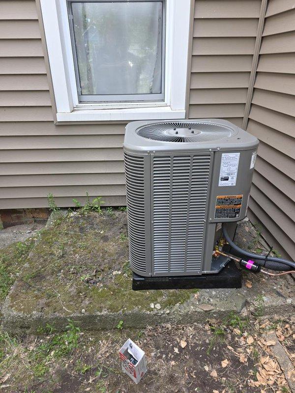 Completed installation of 2-ton air conditioning system with matching evaporator coil on left side of residence. Installed new outdoor condensing unit on existing concrete pad with refrigerant line connections, mounted Siemens electrical disconnect box on exterior wall, and ran new dedicated electrical circuit with proper conduit routing from disconnect to ground entry point. All mechanical and electrical permits obtained prior to installation, system tested and operational upon completion.