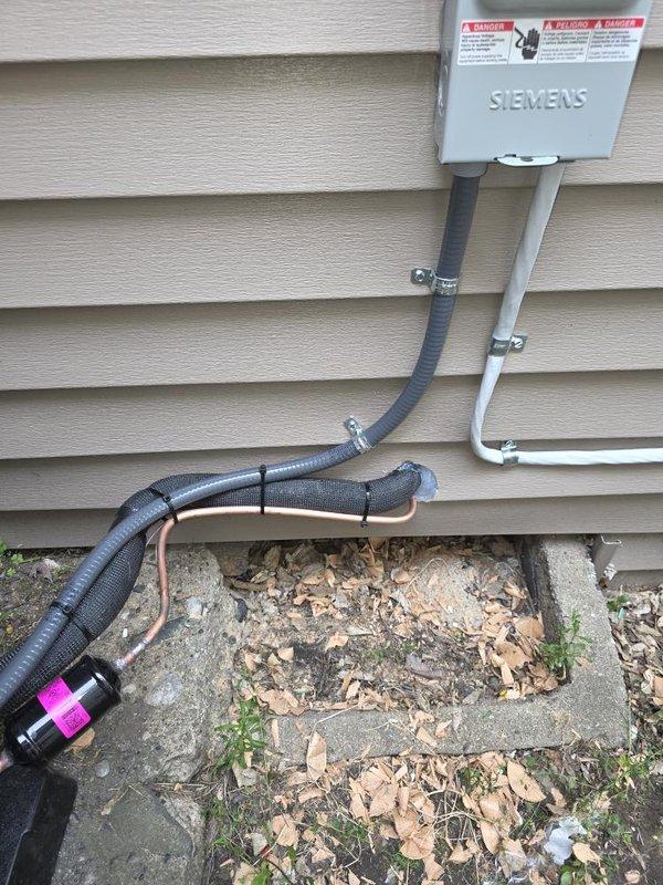 Completed installation of 2-ton air conditioning system with matching evaporator coil on left side of residence. Installed new outdoor condensing unit on existing concrete pad with refrigerant line connections, mounted Siemens electrical disconnect box on exterior wall, and ran new dedicated electrical circuit with proper conduit routing from disconnect to ground entry point. All mechanical and electrical permits obtained prior to installation, system tested and operational upon completion.