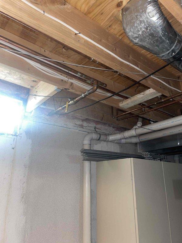 Responded to service call for non-functional air conditioning system with no cooling and inoperative outdoor fan unit. Upon arrival, assessed 23-year-old AC system located on side of residence. Conducted comprehensive evaluation of outdoor condensing unit and indoor components to determine system condition and failure points. Documented existing equipment configuration including exposed ductwork, copper refrigerant lines, and electrical connections in basement utility area. Provided detailed estimate for complete HVAC system replacement due to age of equipment and extent of failure, explaining options and recommendations for new installation to restore cooling capacity to the residence.
