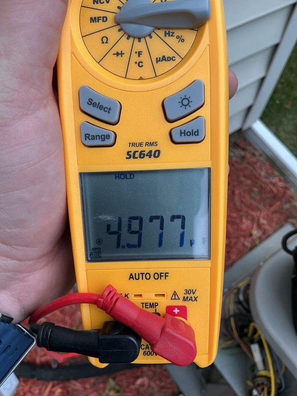 Completed annual cooling maintenance on residential HVAC system. Performed comprehensive system inspection including electrical diagnostics using digital multimeter to verify proper voltage and capacitor readings at outdoor condensing unit. Measured supply voltage at 93.72V and capacitance at 4.977 MFD, confirming components operating within manufacturer specifications. Inspected condenser unit fan motor and compressor operation. Replaced air filter as part of routine maintenance protocol. System tested and verified operational upon completion.