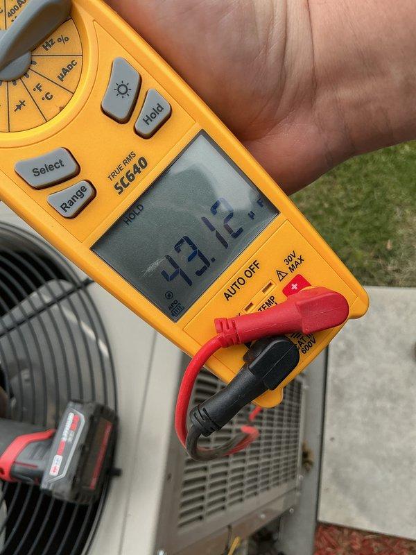 Completed annual cooling maintenance on residential HVAC system. Performed comprehensive system inspection including electrical diagnostics using digital multimeter to verify proper voltage and capacitor readings at outdoor condensing unit. Measured supply voltage at 93.72V and capacitance at 4.977 MFD, confirming components operating within manufacturer specifications. Inspected condenser unit fan motor and compressor operation. Replaced air filter as part of routine maintenance protocol. System tested and verified operational upon completion.