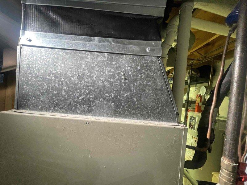 Conducted comprehensive assessment of residential HVAC system for 2,474 square foot home with non-functioning 39-year-old outdoor air conditioning unit. Indoor furnace and air handler confirmed to be in serviceable condition with relatively recent installation. Evaluated existing ductwork system including galvanized metal plenum and distribution components showing normal condensation patterns. Documented current system configuration including copper refrigerant lines, air handler mounting, and duct connections in basement mechanical space. Provided detailed replacement estimate for outdoor condensing unit to restore cooling capacity while utilizing existing indoor equipment and infrastructure.