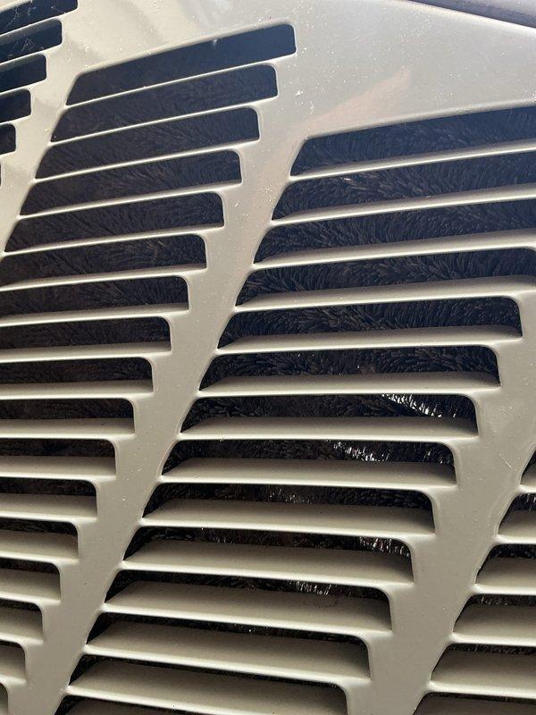 Completed scheduled air conditioning maintenance on ACM unit 6/1710-2. Inspected return air grille showing normal condensation buildup, verified proper airflow through slats and filter screen. Examined evaporator coil assembly, checked refrigerant lines and condensate drain tube for proper routing and connections, confirmed mesh filter condition with typical dust accumulation. All components operating within normal parameters, unit functional and ready for continued service.