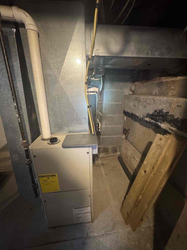 Completed full system estimate for adding central air conditioning to existing forced air heating system. Evaluated 10-year-old furnace unit located in basement utility area, confirmed adequate remaining service life and compatibility for AC integration. Assessed electrical panel capacity and available breaker spaces to determine power requirements for new condensing unit and air handler modifications. Inspected existing ductwork configuration and plenum accessibility for evaporator coil installation. Documented basement moisture concerns on concrete block walls that may require remediation consideration. Photographed furnace, PVC venting, supply/return ductwork, and electrical service panel for equipment specifications and installation planning. Provided comprehensive quote for complete AC system addition including outdoor condensing unit, indoor evaporator coil, refrigerant lines, condensate drainage, electrical connections, thermostat upgrade, and necessary ductwork modifications to