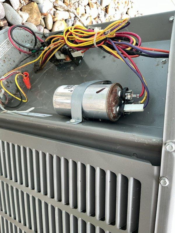 Responded to a no-cooling complaint on a five-year-old residential air conditioning system affecting the entire home. Upon inspection of the outdoor condensing unit, identified a failed dual-run capacitor exhibiting significant rust and corrosion on the terminal end, preventing the compressor and condenser fan motor from operating. Removed the corroded capacitor, verified proper voltage at the contactor, and installed a new dual-run capacitor with correct microfarad ratings for both compressor and fan motor circuits. Tested system operation, confirmed compressor startup and condenser fan rotation, and verified proper amp draw on both circuits. System restored to normal cooling operation with appropriate temperature split across the evaporator coil.