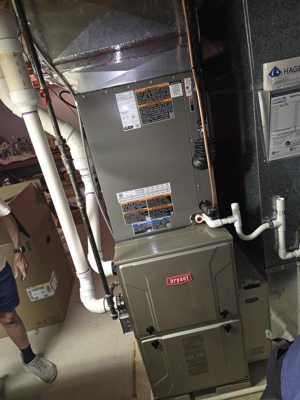 Successfully completed installation of 3.5-ton air conditioning system with matching evaporator coil at residential property. Outdoor condensing unit positioned on concrete pad against exterior wall with proper clearances, connected via refrigerant lines and electrical conduit routed through wall penetration. Indoor evaporator coil installed above existing Bryant furnace in basement utility area with PVC condensate drain lines properly configured. System startup performed with refrigerant line connections verified, electrical connections secured, and all components tested for proper operation. Permit requested for mechanical and air conditioning work prior to installation.