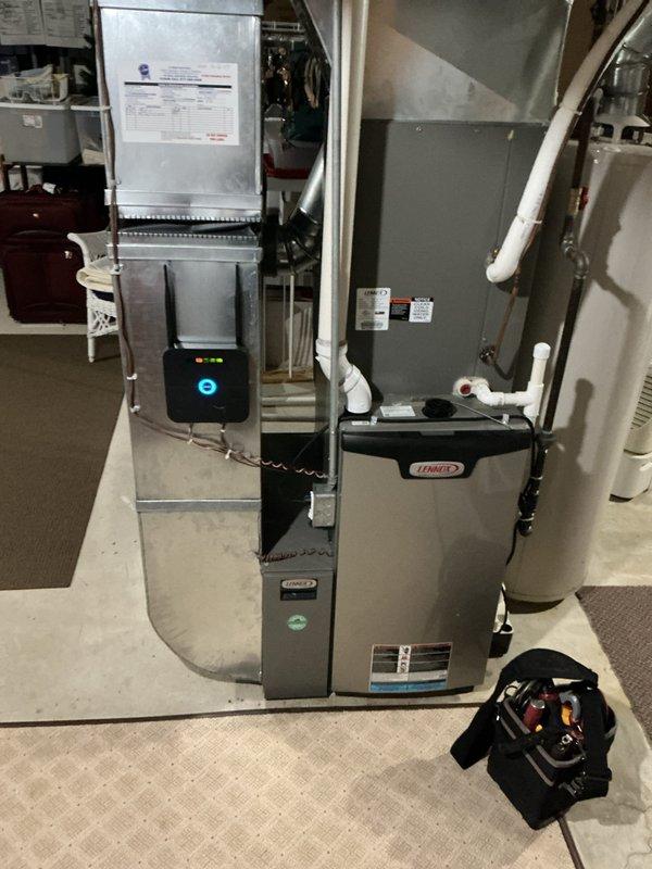 Responded to service call for water leaking from air conditioning unit. Upon arrival, performed comprehensive diagnostic inspection of 8+ year old outdoor condensing unit and indoor HVAC system components including furnace, air handler, and associated ductwork. Inspected evaporator coil drain pan and condensate drain line for blockages or overflow conditions. Examined all refrigerant line connections, fittings, and insulation for signs of moisture accumulation. Verified proper operation of condensate pump if applicable and cleared primary and secondary drain lines as needed. Checked air handler cabinet for water stains or active leaks. Assessed system airflow and filter condition to rule out frozen evaporator coil as leak source. Documented equipment conditions with photographic evidence showing basement mechanical room installation with Lennox furnace, air handler cabinet, and connected ductwork systems. No parts or labor warranty applicable to this unit. Completed diagnostic evaluati