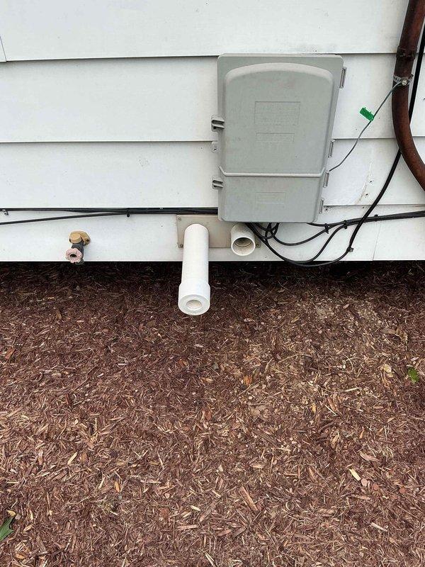 Completed full HVAC system installation including a 70,000 BTU furnace, 2-ton air conditioning unit, and water heater in basement mechanical room. Installed furnace with metallic ductwork on platform, positioned water heater with copper piping connections and blue-handled valves, and mounted exterior AC unit with associated electrical disconnects and refrigerant line connections. Reconnected all electrical and plumbing systems, installed PVC condensate drainage lines through exterior wall, and secured all ductwork and support systems per code requirements.