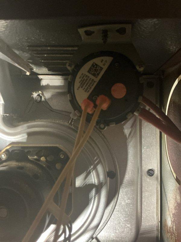 Responded to no-heat call on 10-year-old forced air furnace experiencing ignition failure. Upon inspection, found furnace initiating startup sequence but failing to complete ignition cycle. Diagnosed faulty pressure switch preventing gas valve from opening. Observed significant corrosion on exhaust vent piping and condensate drainage system, indicating moisture infiltration issues that contributed to pressure switch malfunction. Replaced defective pressure switch, cleared condensate drain line obstruction, and verified proper venting operation. Tested ignition sequence through multiple cycles, confirmed flame sensor operation, and validated system heating functionality. Recommended monitoring vent pipe corrosion and considering future vent system replacement to prevent recurring failures.
