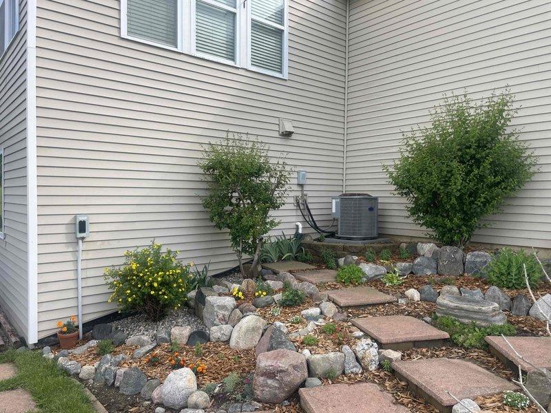 Completed free estimate for replacement of existing 14-15 year old air conditioning system. Evaluated current outdoor condensing unit located in landscaped area with decorative rock garden, assessed refrigerant line routing along exterior wall, and inspected electrical service panel to verify compatibility for new equipment installation. Customer expressed preference for Lennox brand equipment; system currently operational with no reported failures or symptoms, replacement timing to be determined based on weather conditions.