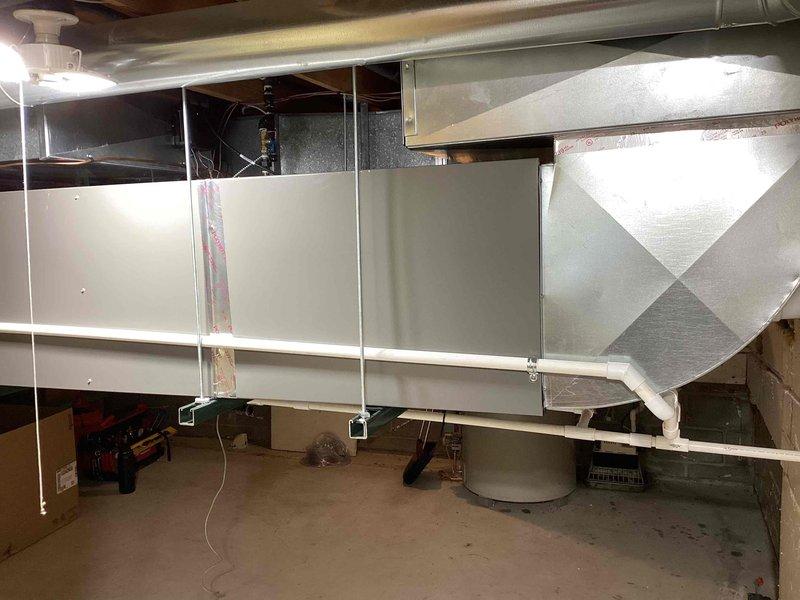 Completed full installation of 5-ton air conditioning system with matching evaporator coil at residential property. Positioned outdoor condenser unit on deck with proper condensate pan and installed electrical disconnect box with PVC conduit connections. Installed indoor air handler with evaporator coil in basement utility area, suspended horizontally with proper ductwork integration and support strapping. Reconnected all electrical connections, established refrigerant lines between indoor and outdoor units, and verified proper airflow through existing ductwork system. All work performed in accordance with mechanical permit requirements for left-side configuration installation.