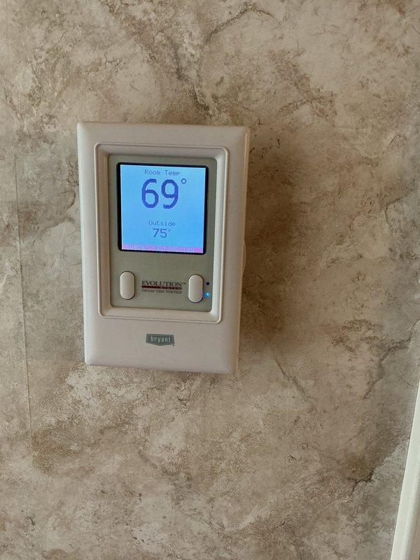 Responded to no-cooling complaint on 14-year-old Bryant central air conditioning system with malfunction message displaying on Evolution thermostat. Upon arrival, found outdoor condenser unit heavily obstructed by overgrown vegetation affecting airflow and system performance. Cleared grass, weeds, and plant growth from around condenser perimeter to restore proper ventilation. Inspected electrical connections at disconnect box and verified proper power supply to unit. Cycled system through startup sequence and confirmed thermostat communication restored with condenser now operating continuously without short-cycling. Unit resumed normal cooling operation with adequate airflow through condenser coils after vegetation removal.