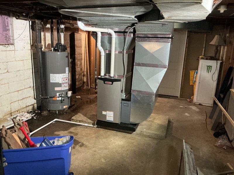 Completed full HVAC system installation in basement utility room, including 70,000 BTU furnace, 2-ton air conditioning unit, and evaporator coil. All equipment properly positioned, secured, and connected to existing ductwork with flexible transitions. System reconnected to electrical service and tested for proper operation upon completion.
