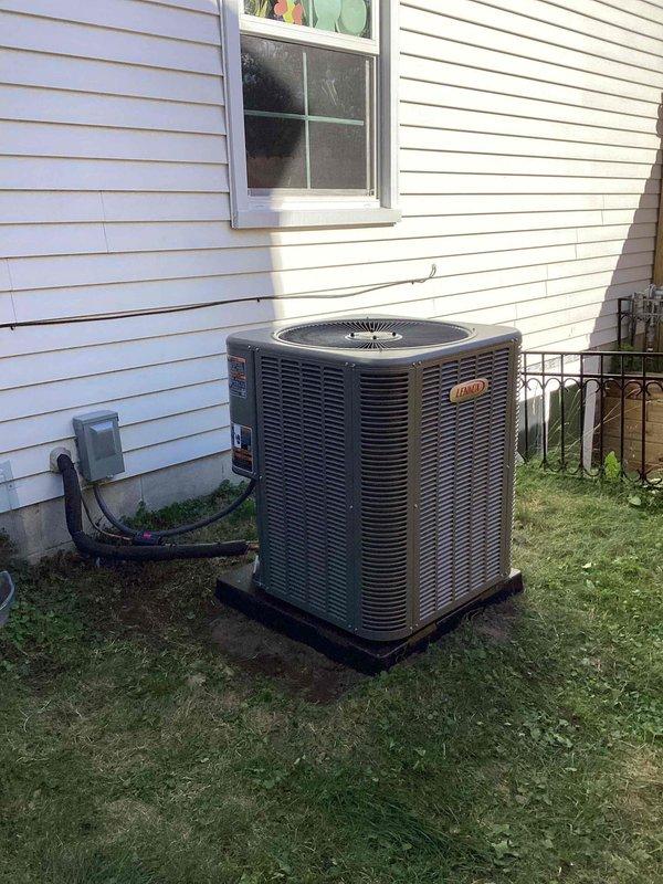 Completed installation of 3-ton Lennox air conditioning condenser unit and evaporator coil at residential property. Unit positioned on black mounting pad on right side of home with proper clearances from structure, electrical disconnect box mounted to exterior wall with conduit run to unit, and all electrical connections completed. Mechanical permit obtained for installation, system reconnected and commissioned to ensure proper operation and refrigerant charge.
