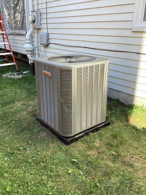 Completed installation of 3-ton Lennox air conditioning condenser unit and evaporator coil at residential property. Unit positioned on black mounting pad on right side of home with proper clearances from structure, electrical disconnect box mounted to exterior wall with conduit run to unit, and all electrical connections completed. Mechanical permit obtained for installation, system reconnected and commissioned to ensure proper operation and refrigerant charge.