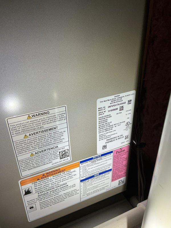 Completed annual cooling maintenance on HVAC system. Performed comprehensive inspection of unit components, verified system specifications and safety labels, and conducted electrical testing with digital multimeter confirming proper voltage readings at 499V. Documented equipment condition with photos for service records.
