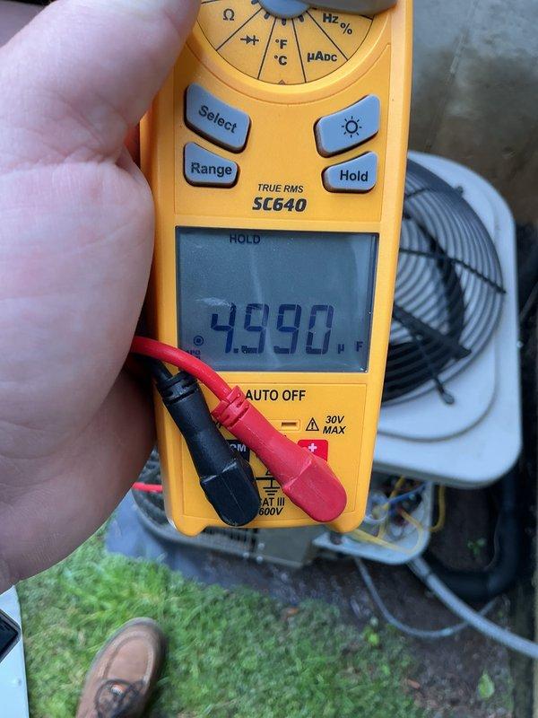 Completed annual cooling maintenance on HVAC system. Performed comprehensive inspection of unit components, verified system specifications and safety labels, and conducted electrical testing with digital multimeter confirming proper voltage readings at 499V. Documented equipment condition with photos for service records.
