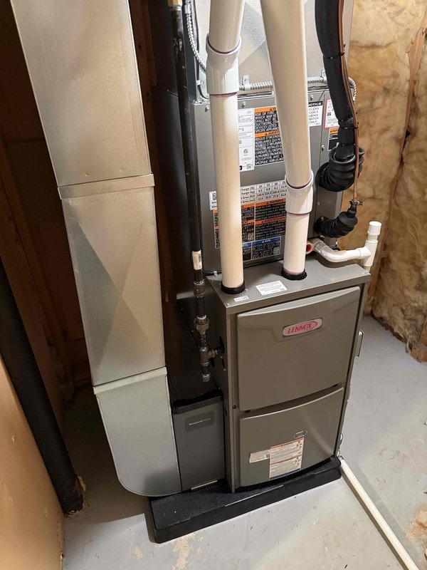 Completed full HVAC system installation including a Lennox 70,000 BTU furnace with coil and 2-ton air conditioning unit configured for right-side placement. Installed white PVC venting system routed through exterior wall with proper elbows and termination, mounted furnace on platform in basement utility area, and reconnected all necessary supply and return ductwork with black flexible connections. Obtained mechanical permit prior to installation and ensured all equipment properly labeled and secured per manufacturer specifications.