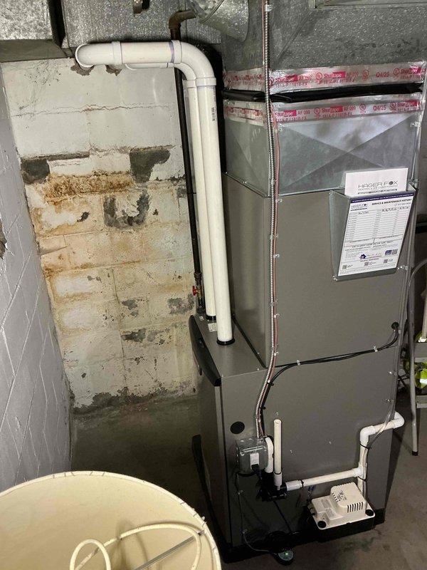 Completed full HVAC system installation in basement utility room, including 90,000 BTU high-efficiency furnace with PVC venting system, 3-ton air conditioning condenser unit positioned at rear of property, and required electrical circuit installation per NEC standards. All mechanical and electrical permits were obtained prior to installation, and system was installed against concrete block wall with proper condensate drainage, electrical conduit routing, and ductwork connections completed to manufacturer specifications.