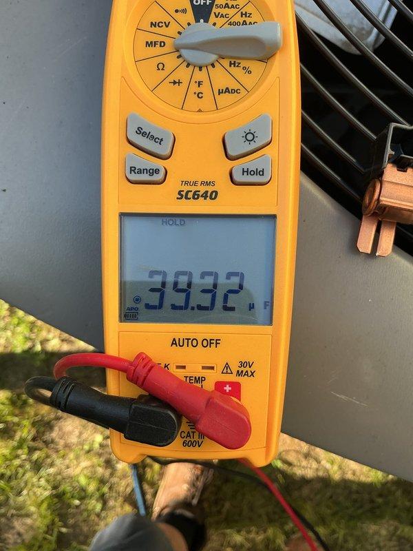 Performed recheck on 2-year-old A/C unit for AirCare member. System confirmed operational and providing adequate cooling. Conducted diagnostic testing using digital multimeter to verify electrical parameters including capacitance reading of 49.74 MFD and run capacitor voltage of 39.32V at outdoor condensing unit. All measurements within manufacturer specifications. Unit operating normally with no issues identified. Documented equipment condition with photos for service records.