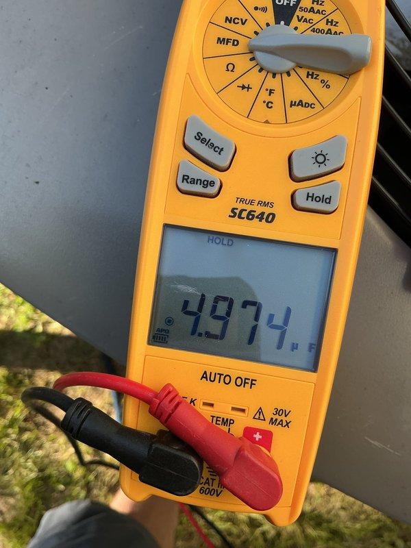 Performed recheck on 2-year-old A/C unit for AirCare member. System confirmed operational and providing adequate cooling. Conducted diagnostic testing using digital multimeter to verify electrical parameters including capacitance reading of 49.74 MFD and run capacitor voltage of 39.32V at outdoor condensing unit. All measurements within manufacturer specifications. Unit operating normally with no issues identified. Documented equipment condition with photos for service records.