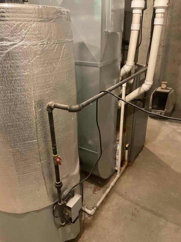 Provided replacement estimate for 20+ year old natural gas furnace located in basement and air conditioning unit positioned at side of house. Current furnace operational; air conditioning unit experiencing intermittent functionality issues. Assessed existing HVAC system configuration including basement mechanical room setup with water heater and filtration equipment, documented equipment specifications and installation requirements for complete furnace and AC replacement recommendation.