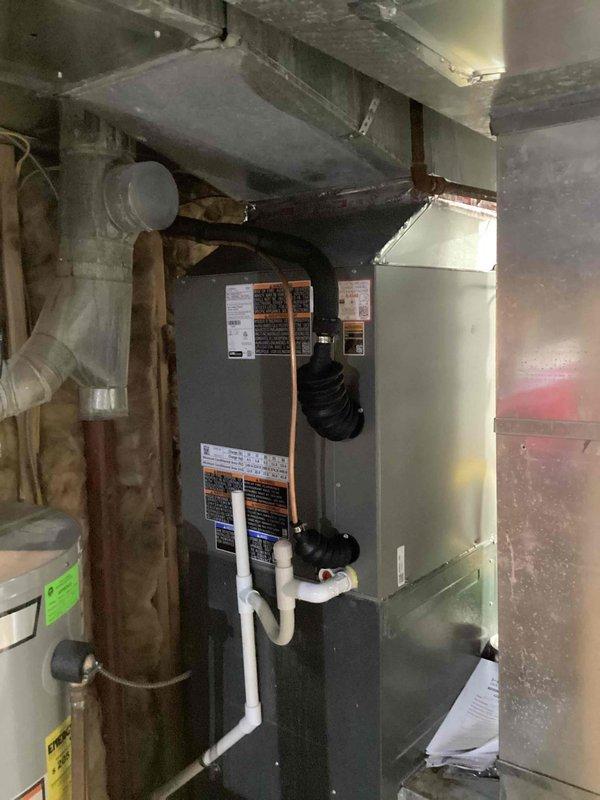 Successfully installed a new 2.5-ton air conditioning system with evaporator coil in basement utility area, with left-side placement configuration and reconnection to existing ductwork and drainage systems. All mechanical permits were obtained prior to installation, and unit was properly connected to furnace/air handler with appropriate refrigerant lines, condensate drainage via white PVC piping, and electrical connections completed per code requirements. Installation included integration with existing HVAC infrastructure, proper mounting and securing of equipment, and verification of all system connections for optimal operation.
