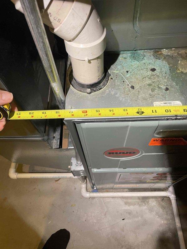 Conducted comprehensive assessment of existing forced air HVAC system for replacement estimate in single-family residence. Inspected 25-year-old outdoor air conditioning unit and Ruud Achiever furnace located in basement, documenting equipment dimensions, clearances, and current installation configuration. Measured spatial requirements around furnace unit and existing PVC venting system to determine replacement equipment specifications and installation feasibility. Photographed existing equipment, ductwork connections, and utility room layout to prepare detailed replacement proposal for complete heating and cooling system upgrade.
