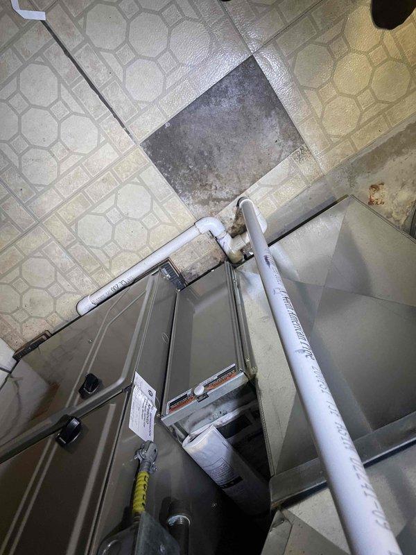 Conducted on-site evaluation of 38-year-old air conditioning system for replacement estimate. Performed visual inspection and documentation of existing HVAC equipment located in mechanical utility room. Assessed current unit configuration, including condensate drainage system with white PVC piping, refrigerant line routing, and overall equipment placement within the space. Took detailed measurements of existing equipment dimensions and clearances to determine replacement unit specifications and compatibility with current installation location. Documented existing system layout, including metallic furnace housing, pipe penetrations, mounting configurations, and available workspace access on hexagonal-patterned tile flooring. Evaluated mechanical room conditions, wall penetrations, and utility connections to prepare comprehensive replacement proposal for new air conditioning system installation scheduled within customer's requested timeframe.