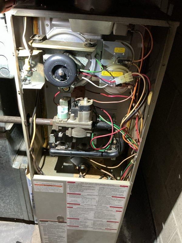 Performed scheduled air handler maintenance on residential gas furnace system. Accessed interior cabinet to inspect blower motor assembly, gas valve components, electrical connections, and associated wiring. Verified proper operation of all mechanical and electrical systems within the unit. Conducted temperature measurements using digital meter, recording operational readings at 76.6°F to confirm system performance parameters. Replaced air filter and evaporator pad as part of routine maintenance protocol. All components found in satisfactory working condition with normal wear patterns consistent with regular operation.