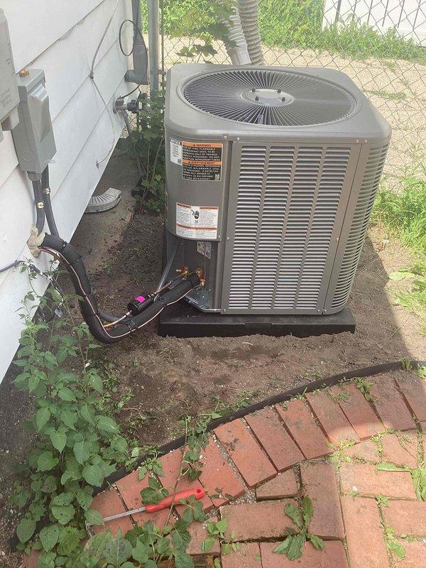 Completed installation of 2.5-ton air conditioning system including outdoor condenser unit and indoor evaporator coil. Condenser unit positioned on concrete pad at rear of property with refrigerant lines and electrical conduit connected to building. System installed per mechanical permit requirements with proper refrigerant charge and electrical connections verified. Unit tested and operational with service and maintenance history documentation provided.