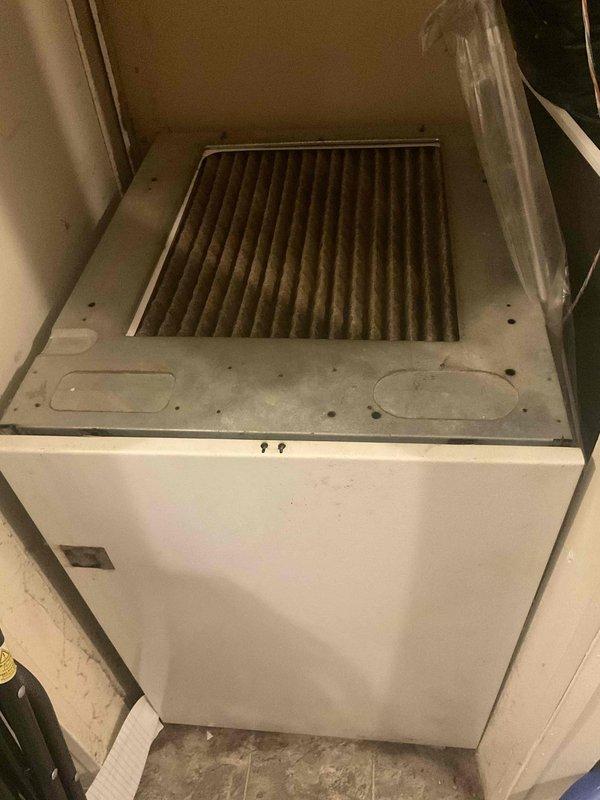 Completed estimate for furnace replacement in residential trailer. Original equipment approximately 30 years old, dating from 1996, with heavily soiled air filter showing significant dust and debris accumulation. Unit located in confined utility closet space with limited access. Customer requested proactive replacement prior to upcoming heating season with no current operational failures reported. Documented existing equipment condition, installation space constraints, and electrical panel configuration for replacement planning purposes.