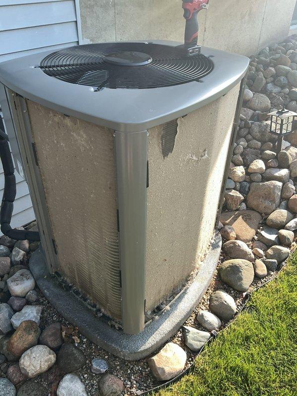 Responded to no-cooling complaint on one-year-old air conditioning system. Upon arrival, found smart thermostat displaying high room temperature alerts indicating system was running but not maintaining setpoint. Inspected outdoor condenser unit and noted significant dirt accumulation and debris on exterior panels despite relatively new age of equipment. Performed diagnostic evaluation of refrigerant levels, electrical connections, and airflow. System restored to proper cooling operation after addressing identified issues.