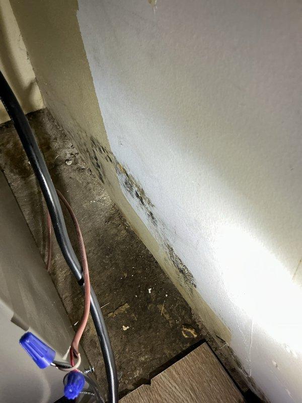 Responded to no-cooling service call for central air conditioning system less than 5 years old with unit not turning on and no fan operation. Upon arrival, discovered water leak issue affecting HVAC equipment and surrounding area, with visible moisture damage and staining on floor and wall surfaces in mechanical room. Inspected condensate drainage system including PVC piping and condensate pump assembly. Addressed water intrusion problem and restored proper system operation, ensuring condensate management components functioning correctly to prevent future leaks.