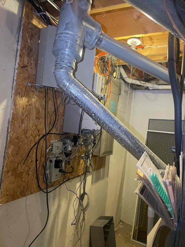 Conducted replacement estimate for 30-year-old central air conditioning system at occupied residence. Inspected existing HVAC equipment in basement mechanical room, documenting ductwork configuration, electrical connections, and equipment placement. Photographed existing installation including flexible duct runs, OSB utility wall with electrical components, and measured equipment dimensions to prepare comprehensive replacement proposal for system upgrade within 30-day timeline.