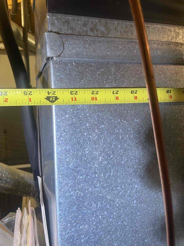 Conducted replacement estimate for 30-year-old central air conditioning system at occupied residence. Inspected existing HVAC equipment in basement mechanical room, documenting ductwork configuration, electrical connections, and equipment placement. Photographed existing installation including flexible duct runs, OSB utility wall with electrical components, and measured equipment dimensions to prepare comprehensive replacement proposal for system upgrade within 30-day timeline.