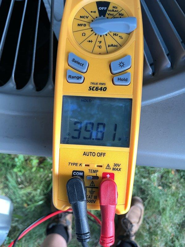 Completed routine Air Care Cooling maintenance on outdoor HVAC unit. Performed electrical diagnostics using digital multimeter, measuring capacitor voltage at 598.1V and verifying system amperage draw at 0.64A with corresponding voltage reading of 0.2V on condenser coil assembly. All measurements within normal operating parameters for the equipment.