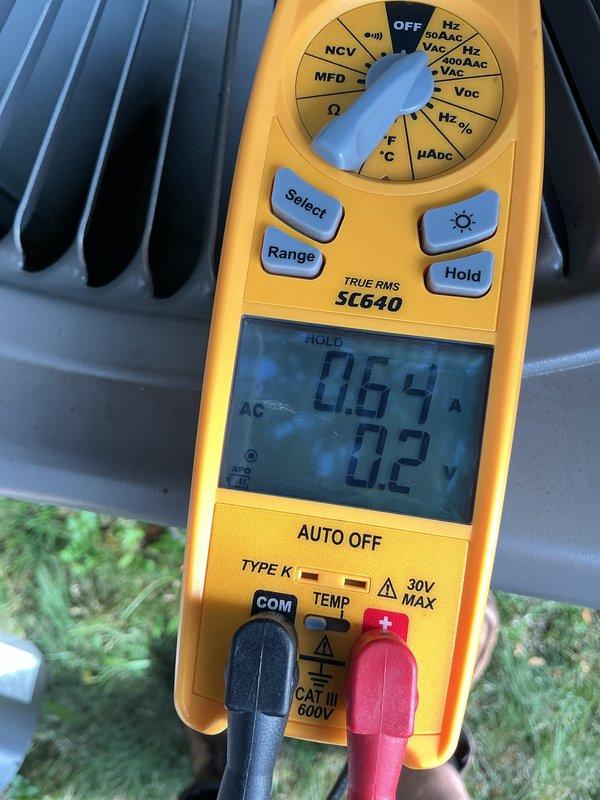 Completed routine Air Care Cooling maintenance on outdoor HVAC unit. Performed electrical diagnostics using digital multimeter, measuring capacitor voltage at 598.1V and verifying system amperage draw at 0.64A with corresponding voltage reading of 0.2V on condenser coil assembly. All measurements within normal operating parameters for the equipment.