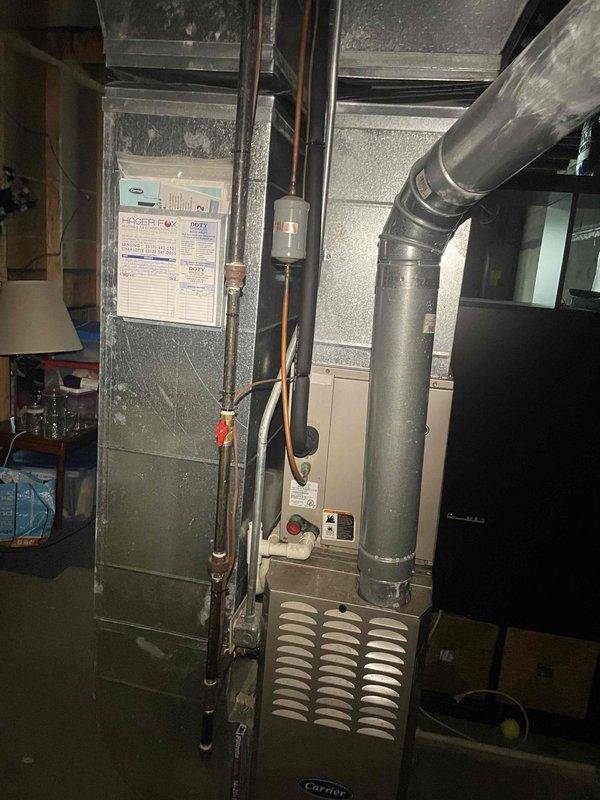 Conducted site assessment for complete HVAC system replacement on existing 20-year-old air conditioning unit and Carrier furnace system. Documented current equipment configuration including outdoor condensing unit, indoor furnace with existing ductwork, and refrigerant line routing in basement installation. Photographed equipment specifications, model information, and spatial layout to prepare comprehensive replacement estimate for customer requesting expedited installation timeline.