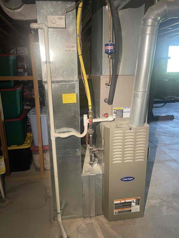 Provided estimate for complete whole home comfort package replacement including furnace and air conditioning system. Existing 16+ year old Carrier furnace and AC system currently operational but nearing end of service life. Equipment located in basement utility room with natural gas fuel source, existing ductwork and venting infrastructure in place for replacement installation.