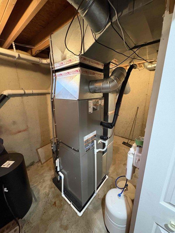 Completed full HVAC system installation including a 90,000 BTU furnace and 3.5-ton air conditioning unit with right-side configuration. Installed new ductwork connections, humidifier integration, and reconnected all mechanical systems. Positioned outdoor condenser unit with proper electrical disconnect box and condensate drainage, while the indoor furnace was installed in the basement utility area with appropriate venting and PVC piping connections.