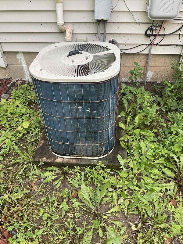 Completed whole-home air conditioning system estimate for replacement of aging outdoor condenser unit and indoor furnace system. Assessed existing equipment showing significant weathering and age-related deterioration on exterior condenser with corroded protective cage and overgrown vegetation at base. Documented indoor furnace installation in basement utility area with existing ductwork configuration and PVC condensate drainage. Provided comprehensive replacement recommendations to address immediate cooling needs per customer's request for expedited installation timeline.