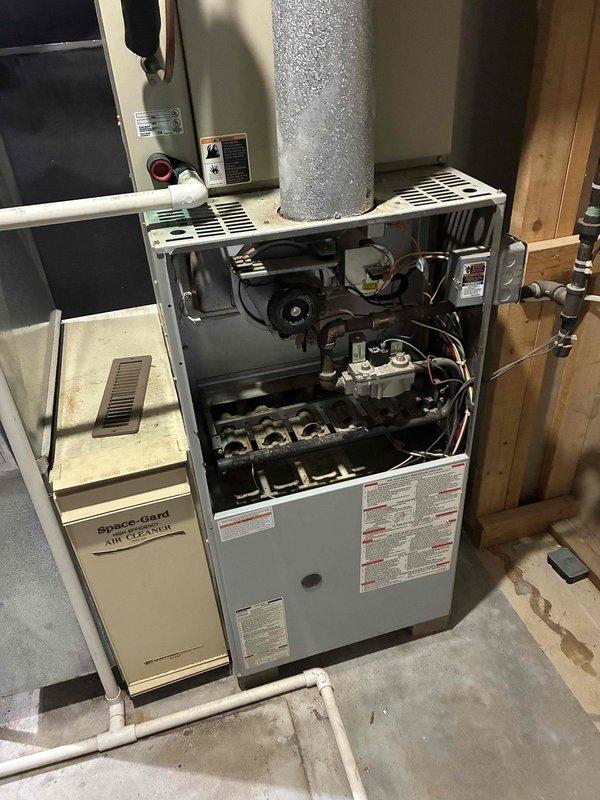 Performed comprehensive evaluation of existing HVAC system with failed AC compressor. Both furnace and air conditioning units were determined to be approximately 26 years old and at end of serviceable life. Documented current equipment specifications and installation configuration in basement mechanical room, including furnace with integrated humidifier, ductwork layout, and outdoor condensing unit. Assessed electrical connections, gas supply lines, and existing duct system compatibility. Provided detailed estimate for complete furnace and AC system replacement to address immediate replacement needs.