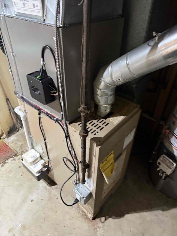 Completed installation of 2-ton air conditioning system with evaporator coil at rear location of residence. Installed outdoor Lennox condenser unit on gravel pad with proper refrigerant line connections and electrical service, including conduit and disconnect. Mounted indoor evaporator coil to existing furnace system with appropriate ductwork connections, installed wall-mounted air handler controls with electronic monitoring device, and completed all electrical wiring and safety connections. Obtained mechanical and electrical permits prior to installation and verified all components operational upon system startup.