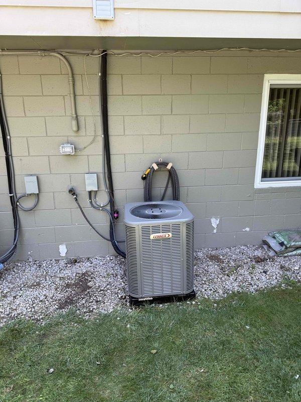 Completed installation of 2-ton air conditioning system with evaporator coil at rear location of residence. Installed outdoor Lennox condenser unit on gravel pad with proper refrigerant line connections and electrical service, including conduit and disconnect. Mounted indoor evaporator coil to existing furnace system with appropriate ductwork connections, installed wall-mounted air handler controls with electronic monitoring device, and completed all electrical wiring and safety connections. Obtained mechanical and electrical permits prior to installation and verified all components operational upon system startup.