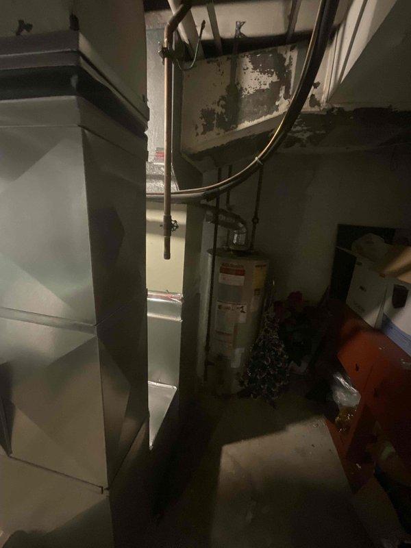 Provided comprehensive estimate for air conditioning system replacement in basement installation. Current A/C unit from 1997 remains operational but has reached end of expected service life at 27 years old. Assessed existing HVAC infrastructure including aged ductwork with visible deterioration, evaluated basement utility space configuration with water heater and existing furnace equipment that was replaced in 2023. Documented equipment placement, existing duct connections, and structural conditions including ceiling damage that may impact installation access. Prepared detailed replacement proposal outlining equipment specifications and installation requirements for new air conditioning system to integrate with recently installed furnace.
