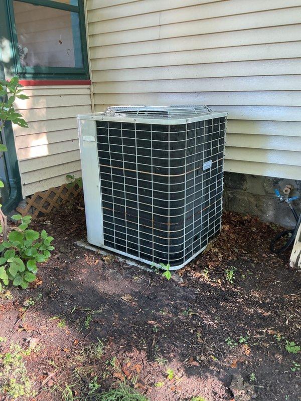 Completed annual cooling maintenance on residential outdoor condensing unit. Performed standard ACM protocol including inspection of condenser coils, cabinet condition, and surrounding clearances. Unit operating within normal parameters with no immediate service needs identified. Exterior cabinet and protective grilles show normal wear consistent with age, and adequate airflow clearance maintained around unit perimeter.