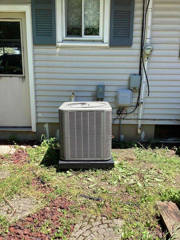 Completed installation of 2.5-ton air conditioning system with evaporator coil at residential property. Outdoor condensing unit positioned on platform at rear of home with proper electrical connections and refrigerant lines run to indoor air handler. Indoor evaporator coil installed in basement mechanical room and connected to existing ductwork, with all components tested and operational upon completion.